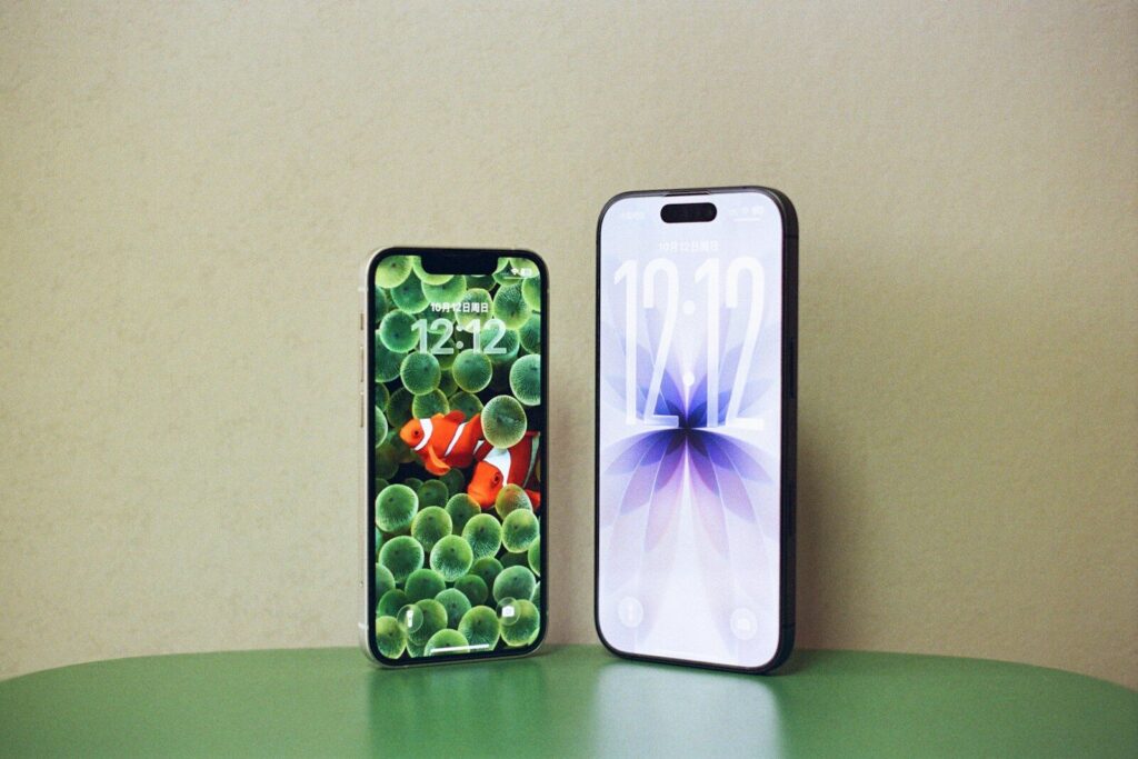 Two smartphones displaying different wallpapers on a table.