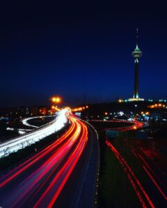 Stunning long exposure of Tehran's Milad Tower with light trails on the expressway at night.