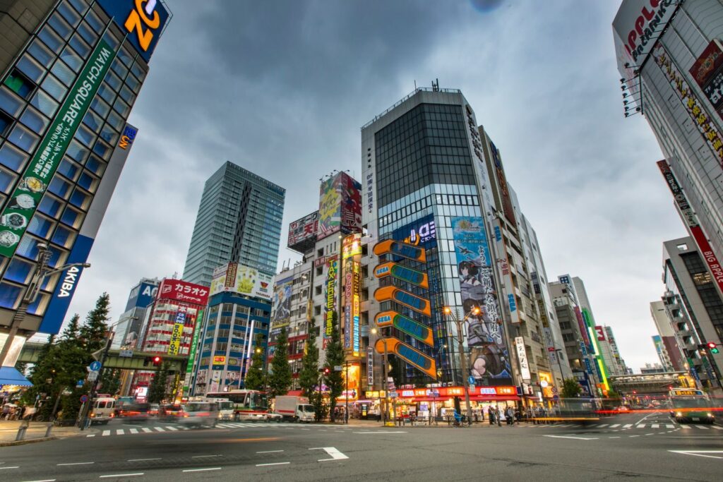 Dynamic street scene of Shinjuku, Tokyo with towering skyscrapers and bustling activity.