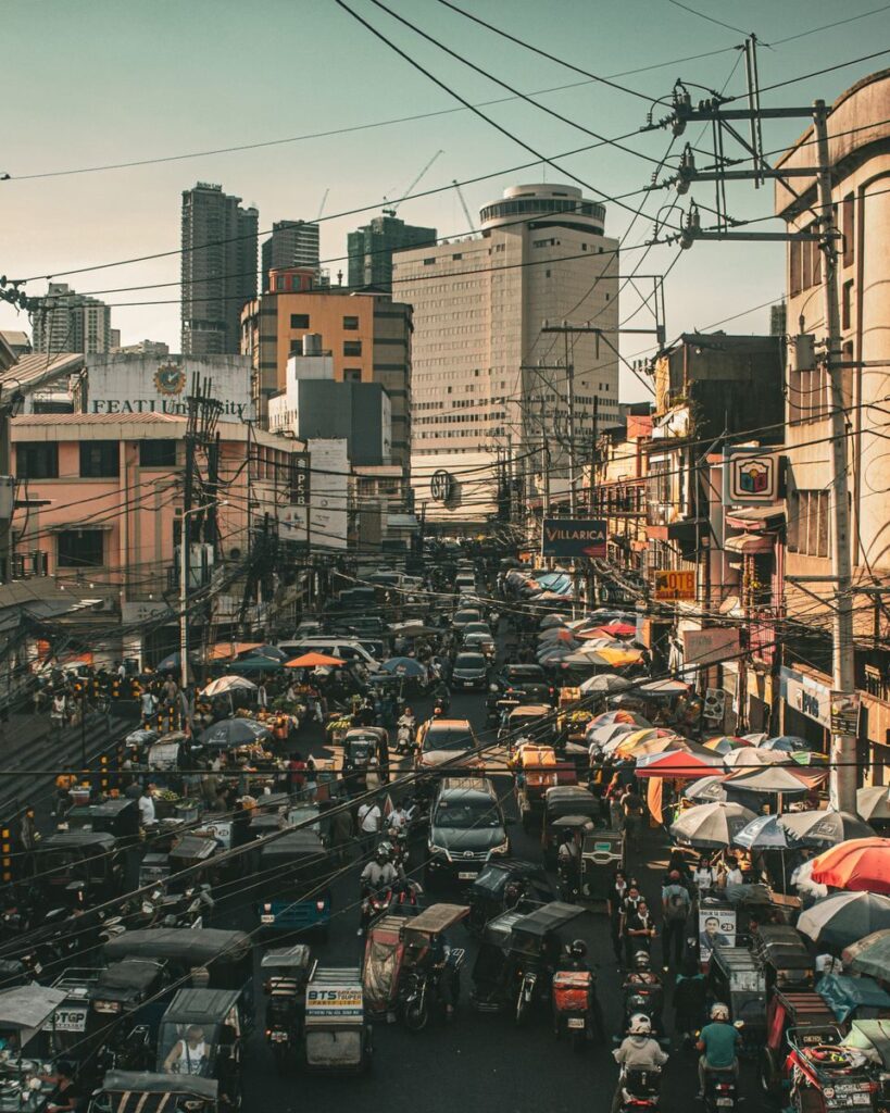 Crowded street scene in Manila, showcasing urban life and traffic.