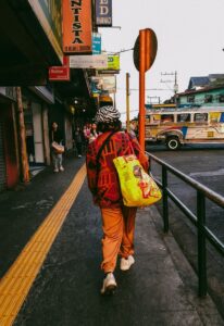 A vibrant street capture in Baguio, Philippines, featuring a local carrying a colorful bag.