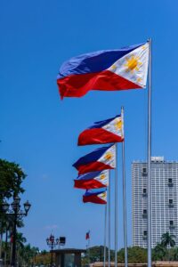 Vibrant Philippine flags waving outdoors with blue sky in Pasay City, NCR, Philippines.